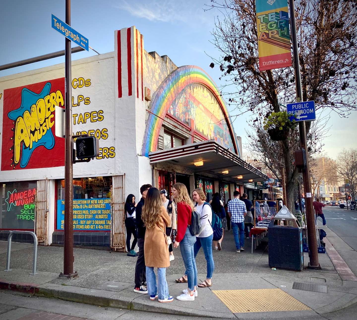 Exterior on Telegraph Ave with rainbow arch facade and a crowd of shoppers.