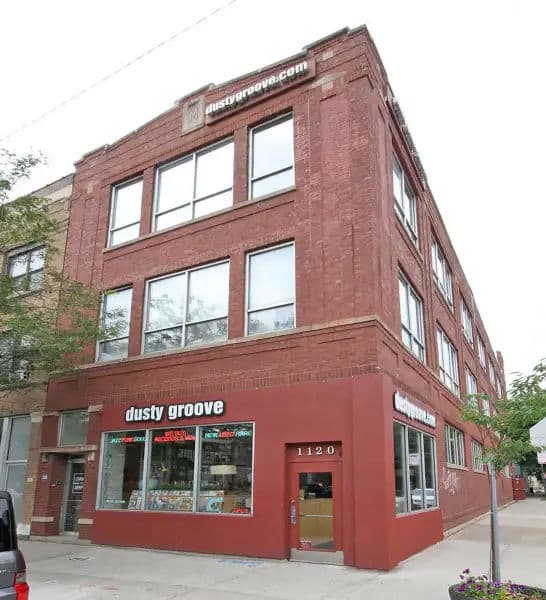 Exterior of Dusty Groove record store in Chicago, located in a red brick building with large front windows showcasing vinyl.