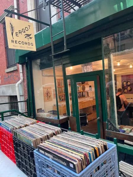 Exterior of Ergot Records in New York City, with green trim around the door and windows, a yellow hanging sign above the entrance.