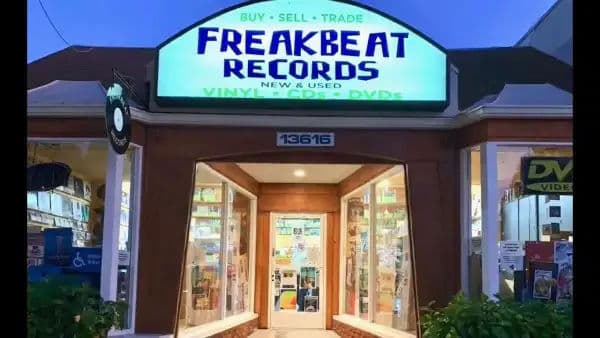 Front entrance of Freakbeat Records in Sherman Oaks, glowing under a bright blue evening sky.