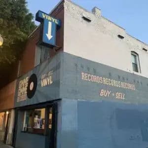 Street view of Gimme Gimme Records in Los Angeles, a corner shop with retro signage reading Buy + Sell Vinyl.