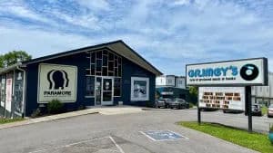 Exterior of Grimey's record store in Nashville, featuring a large mural of Paramore and Taylor Swift on the building and a sign that reads 'Grimey's New & Preloved Music & Books.'