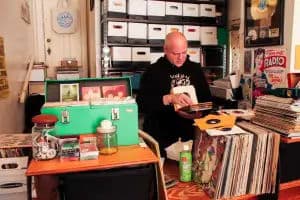 Small San Francisco boutique focused on soul/funk 45s; owner flipping through singles behind a counter stacked with records and crates.