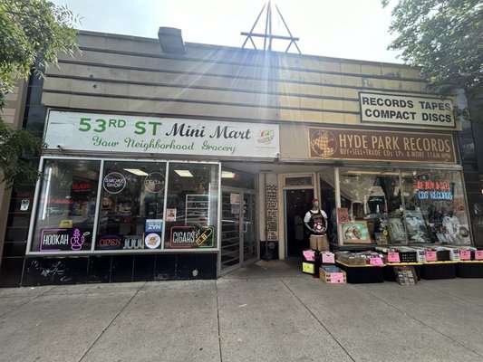 Street view of Hyde Park Records in Chicago, with vinyl bins displayed outside and signage advertising records, tapes, and CDs.