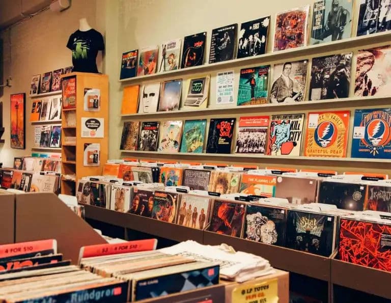 Warm, well-lit LP bins with a wall shelf of featured album covers and bargain dividers at Jive Time Records.