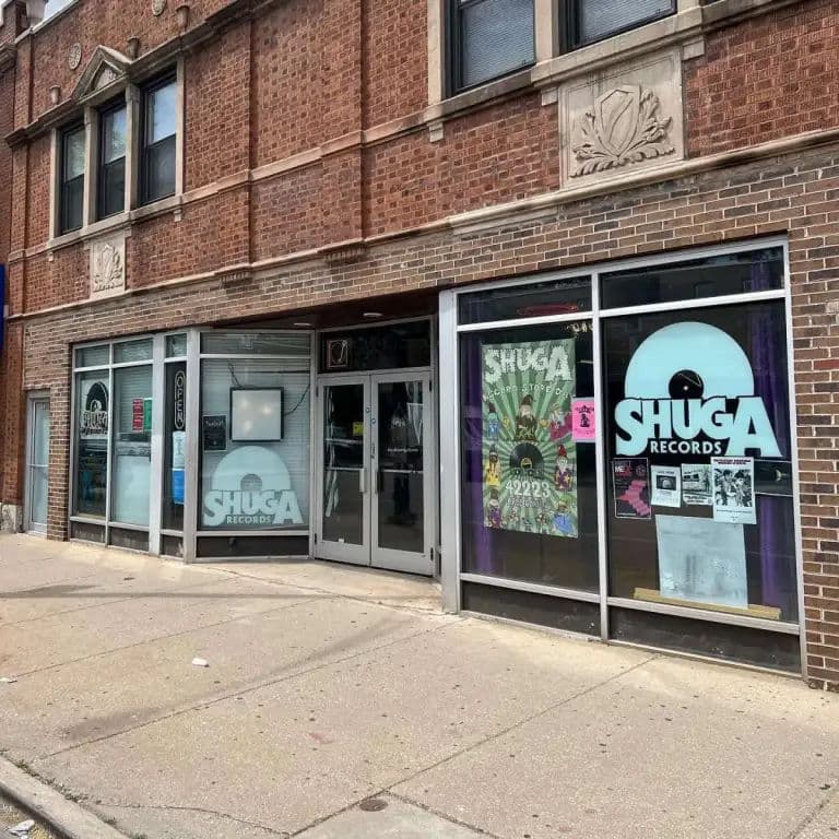Exterior of Shuga Records in Chicago, with large window displays and posters promoting Record Store Day.