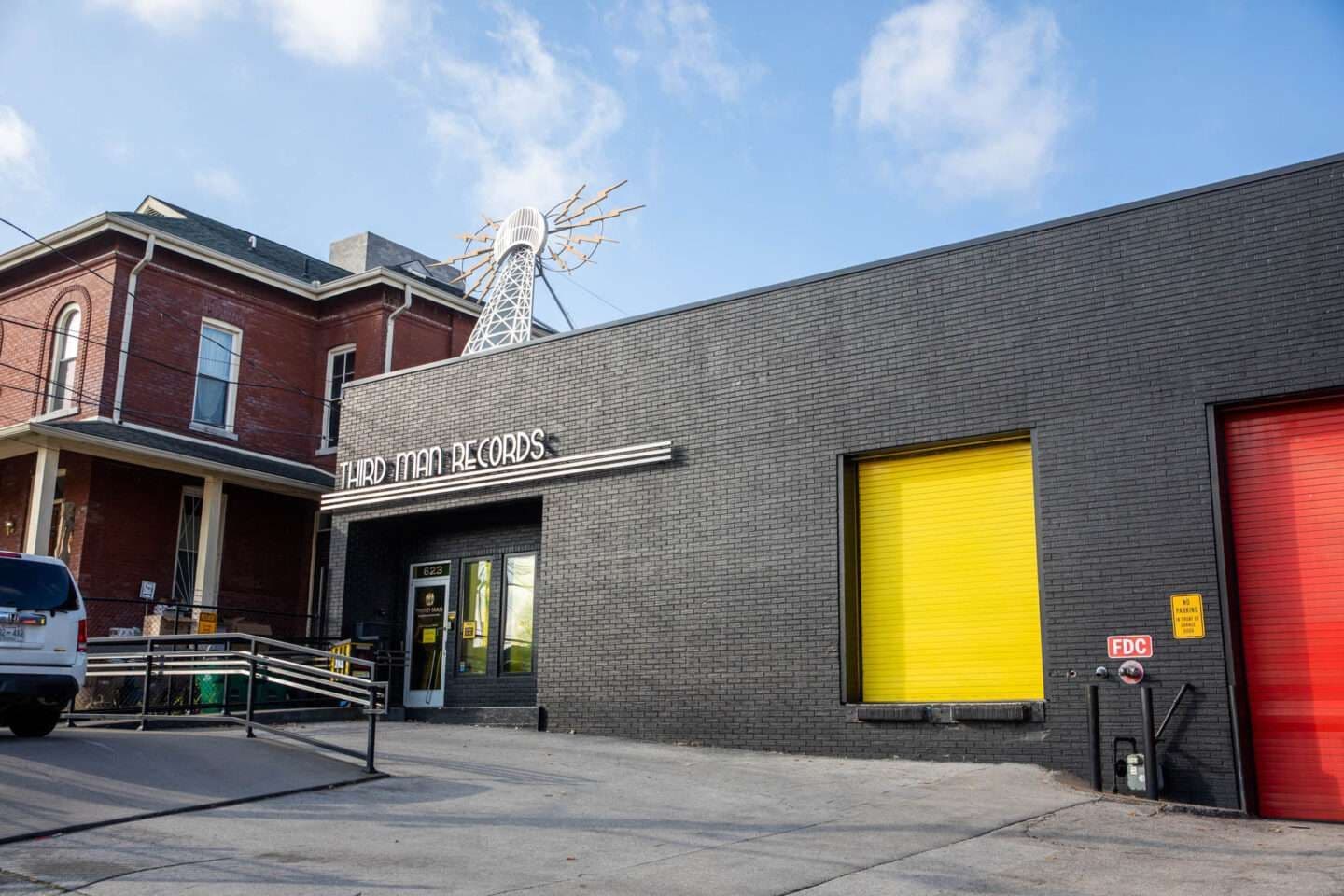 Inside Third Man Records with a bright yellow wall, counter space, merchandise, and turntables, creating a modern yet retro music store vibe.